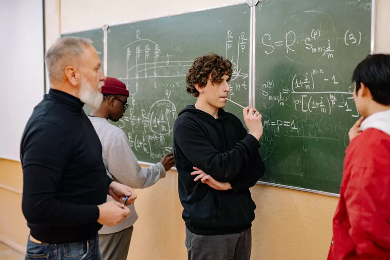 Students calculating complex equations with lecturer