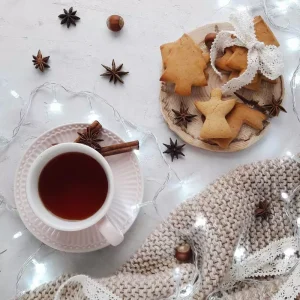 Christmas biscuits, cinnamon sticks, woven blanket and tea