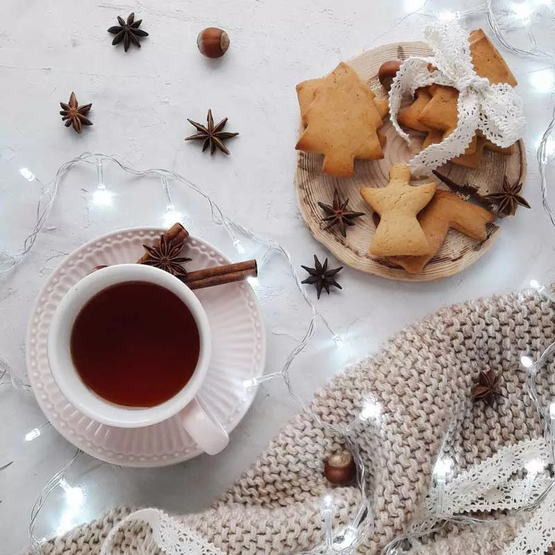 Christmas biscuits, cinnamon sticks, woven blanket and tea
