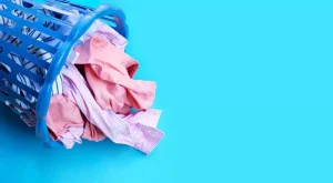 Tipped basket of washing over blue background